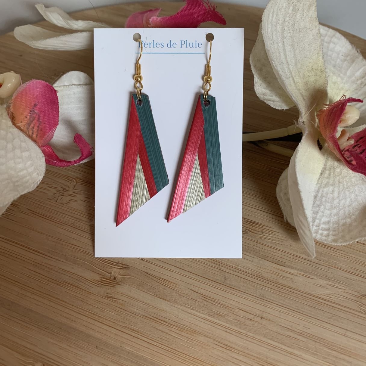 Boucles d'oreilles pendantes géométriques en marqueterie de paille rouge et bleu.