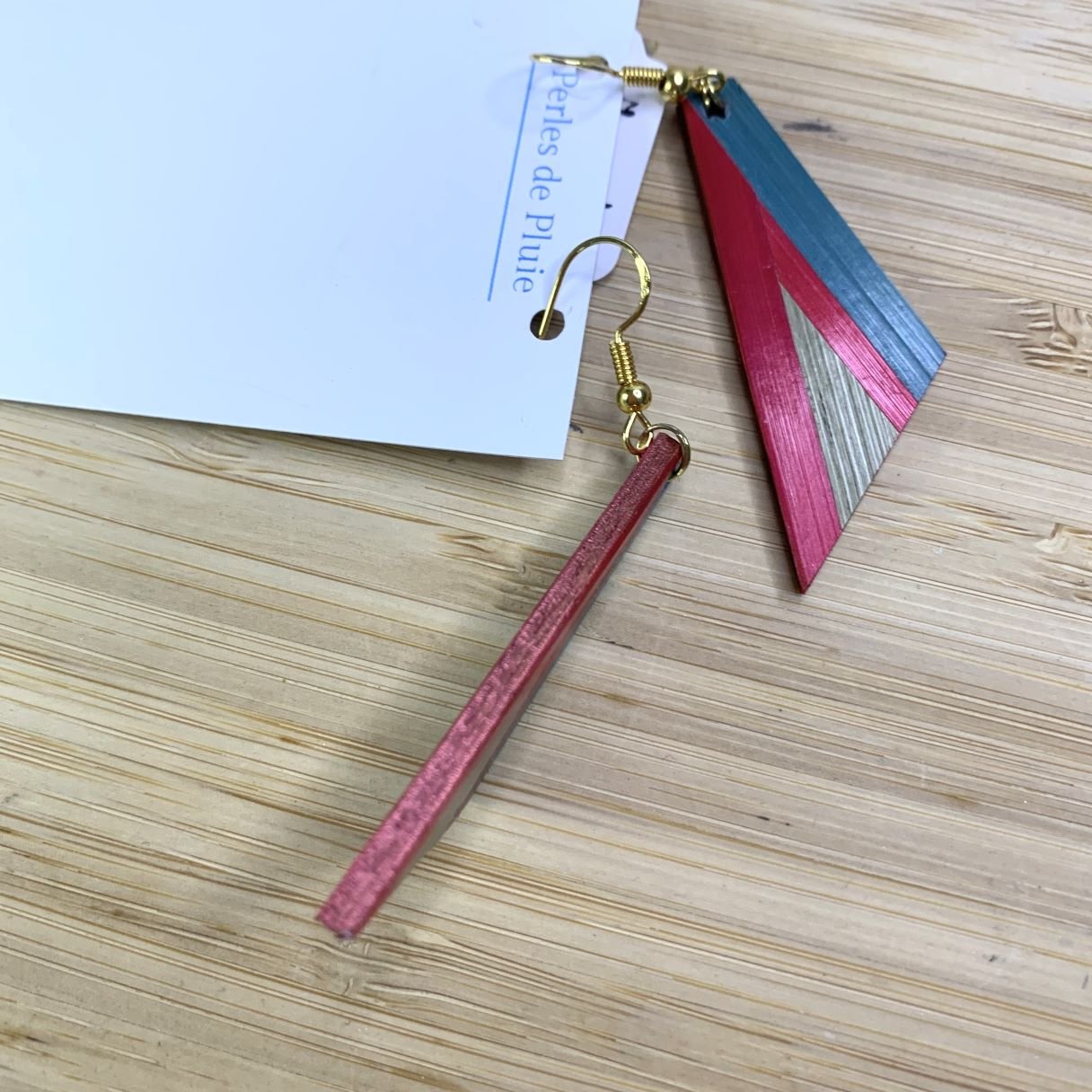 Détail de la finesse d'une boucle d'oreille en marqueterie de paille de profil.