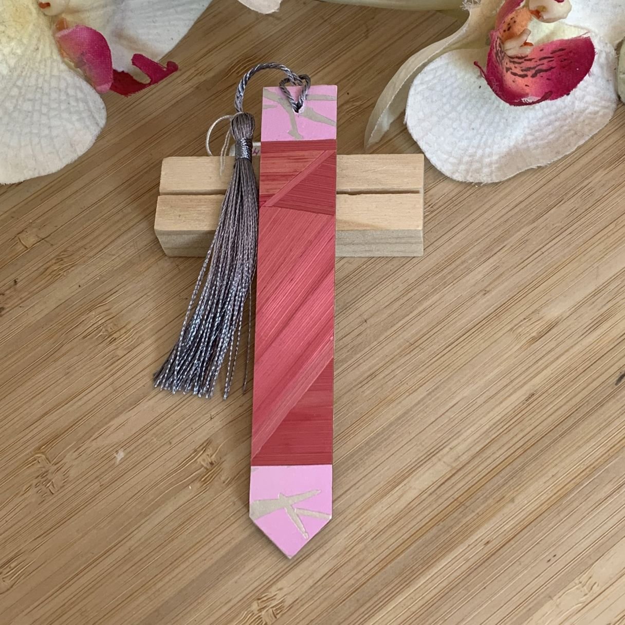 Marque-pages artisanal en marqueterie de paille rose avec pompon gris et papier aux traits argentés au recto