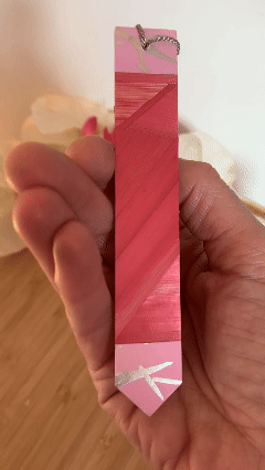 Marque-pages artisanal en marqueterie de paille rose avec pompon gris et papier aux traits argentés au recto