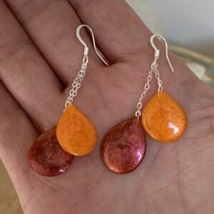 boucles d&rsquo;oreilles collection: gouttes en résine et pigments faites à main levée. Solaire. Photo prise du bijou dans ma main.jpg