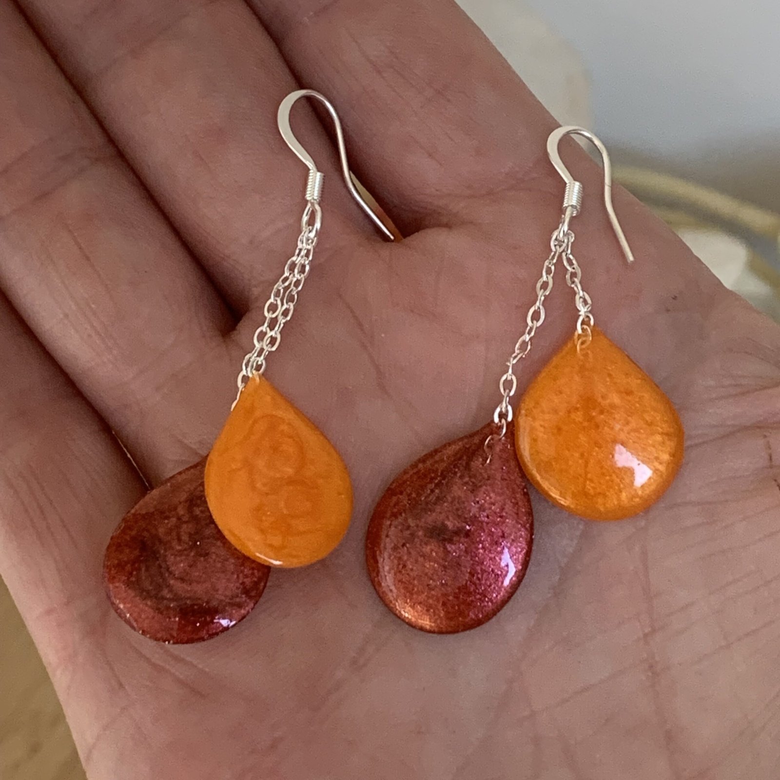 boucles d&rsquo;oreilles collection: gouttes en résine et pigments faites à main levée. Solaire. Photo prise du bijou dans ma main.jpg
